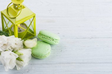 Mavi yeşil macaroons ve yanan mum fener