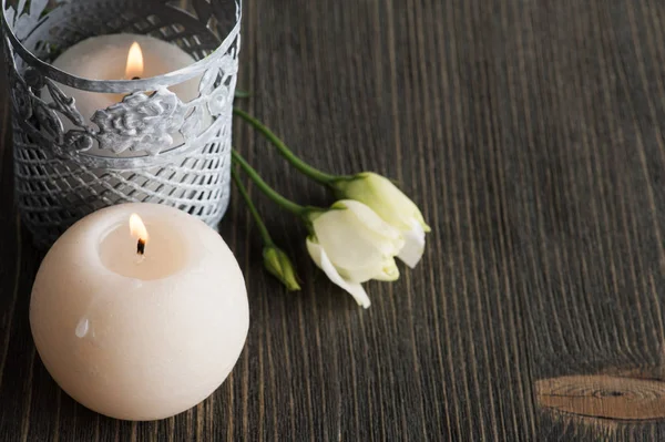 Brennende Kerzen und weiße Blumen auf dunklem rustikalen Tisch — Stockfoto