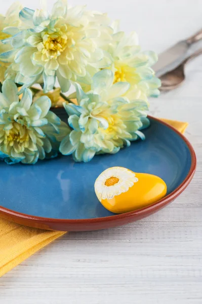 Chrysant bloemen op een plaat op een houten tafel — Stockfoto