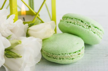 Mavi yeşil macaroons ve yanan mum fener