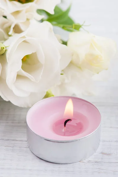 Arreglo de flores de eustoma blanco y vela rosa encendida —  Fotos de Stock