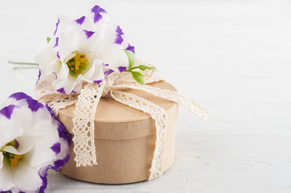 Hand gemaakte gift en bloemen — Stockfoto