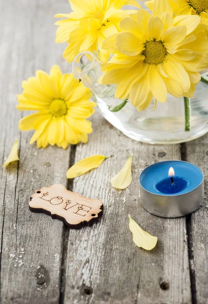 Verse gele daisy bloemen, ondertekenen van liefde en stak kaars — Stockfoto