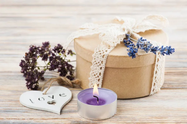 Regalo con lazo de encaje, flor de lavanda, vela encendida —  Fotos de Stock