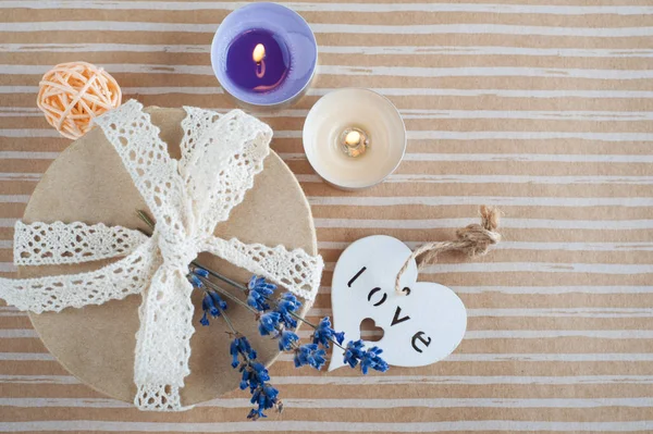 Geschenk mit Spitzenschleife, Lavendelblume, brennender Kerze — Stockfoto