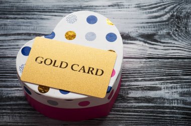 Kalp şekli pembe kutu üzerinde parıldayan altın kartı