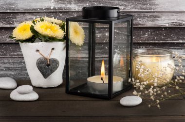 Mumlar ile beton tencerede sarı krizantem