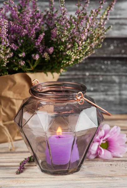 Розовая вереск и свеча в геометрической стеклянной вазе — стоковое фото