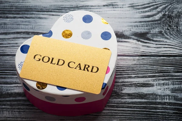 Kalp şekli pembe kutu üzerinde parıldayan altın kartı