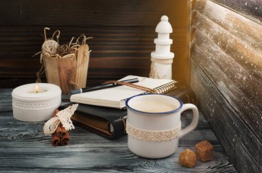 Açık not defteri, mum, kalem ve kahve