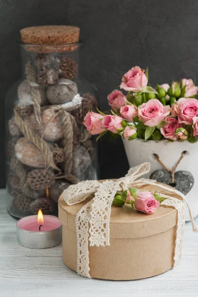 Розовые розы в бетонном горшке со свечой — стоковое фото