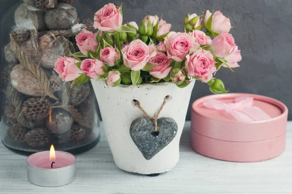 Рожеві троянди в бетонному горщику зі свічкою — стокове фото