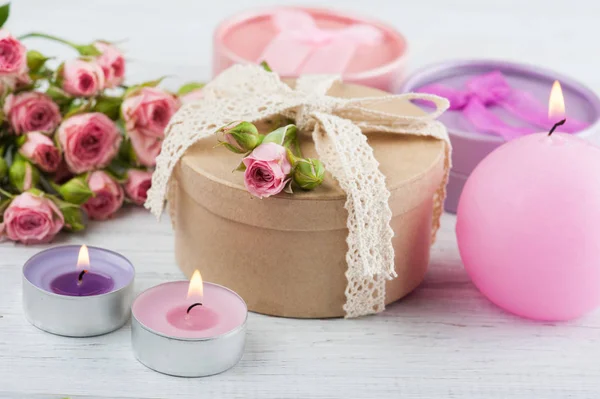 Roze rozen met gave en kaarsen — Stockfoto
