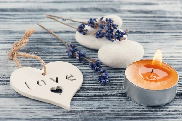 Flores de lavanda, vela naranja encendida y corazón —  Fotos de Stock