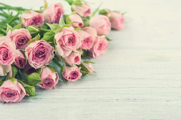 Ροζ τριαντάφυλλα σε λευκό ξύλινο φόντο — Φωτογραφία Αρχείου