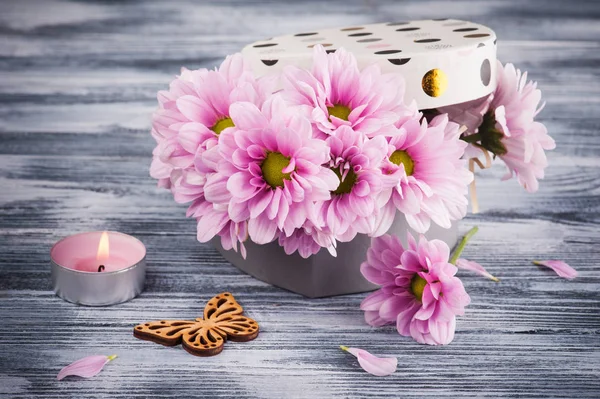 Crisântemo rosa em caixa de presente, vela acesa e borboleta — Fotografia de Stock