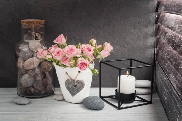 Rosas rosadas en maceta de hormigón con vela —  Fotos de Stock