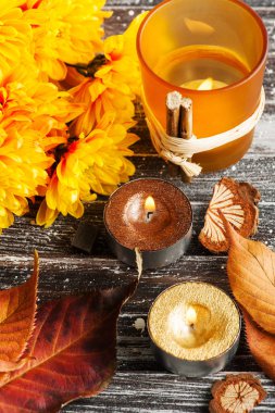 Sarı krizantem, aydınlatılmış altın mumlar ve yaprakları