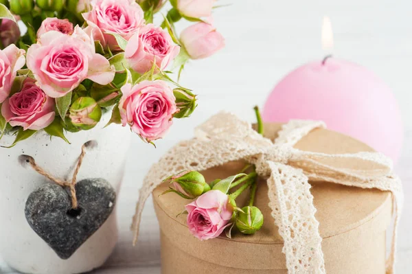 Rosas cor-de-rosa em vaso de concreto com vela — Fotografia de Stock
