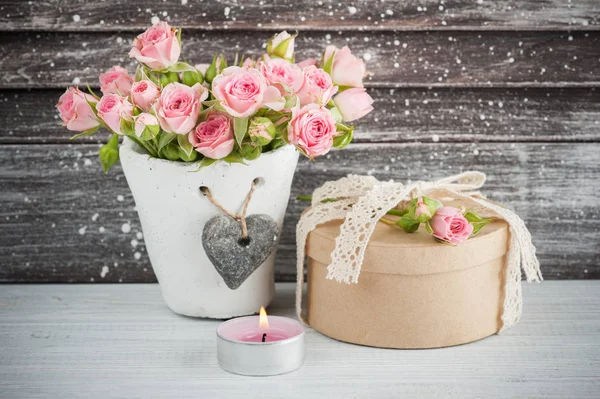 Rosas rosadas en maceta de hormigón con vela —  Fotos de Stock