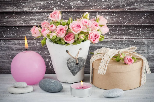 Rosas cor-de-rosa em vaso de concreto com vela — Fotografia de Stock