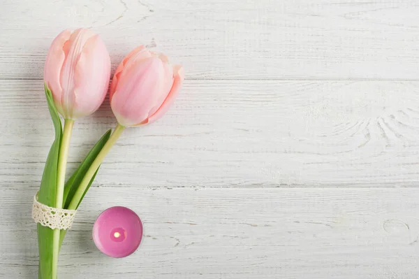 Flores de tulipán rosa, vela encendida —  Fotos de Stock