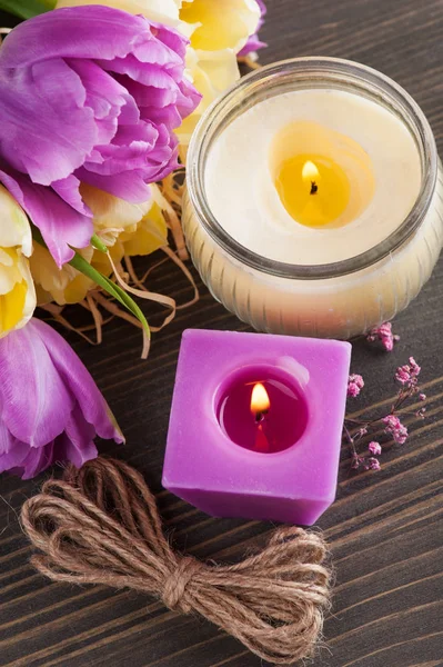 Purple yellow tulips, lit candles — Stock Photo, Image