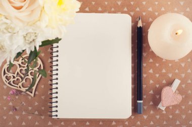 Defter, çiçek ve yanan mum