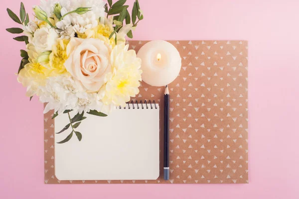 Anteckningsbok, blommor och tänt ljus — Stockfoto