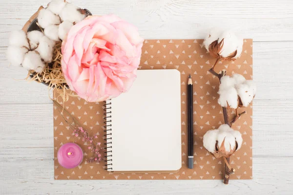 Caderno, flores e vela acesa — Fotografia de Stock