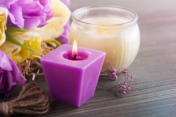 Фиолетовые желтые тюльпаны, зажженные свечи — стоковое фото