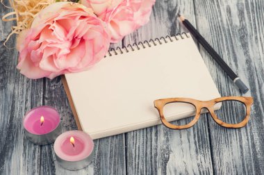 Defter, çiçek ve yanan mumlar