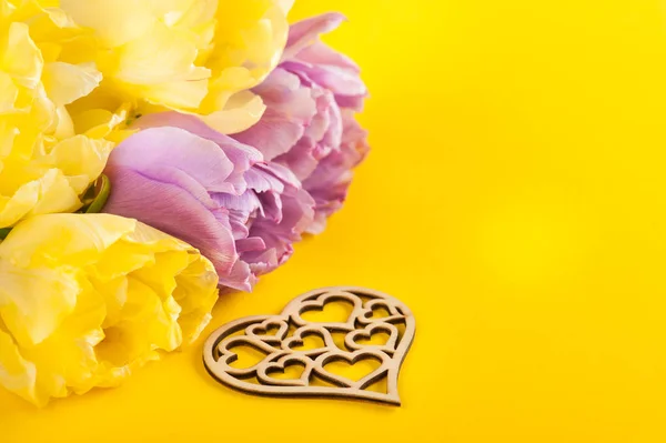 Gele tulp bloemen, houten hart — Stockfoto