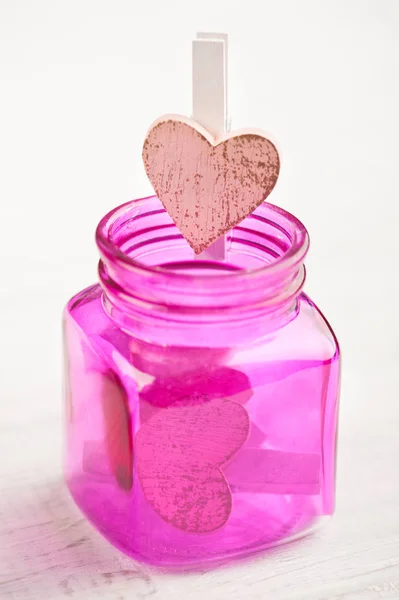 Roze fles met houten hart — Stockfoto