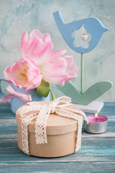 Рожеві квіти тюльпанів, запалена свічка — стокове фото