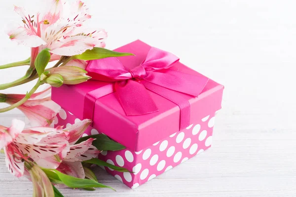 Roze lelie bloemen met geschenkdoos — Stockfoto