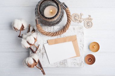 Kalitesiz ahşap arka planda boş not ve kraft zarfı. Metin ve yanan mumlar için alanı kopyala