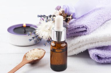 Temel yağ, banyo tuzu ve yanık lavanta mumu kaplıcada kuru çiçekler ve havlularla