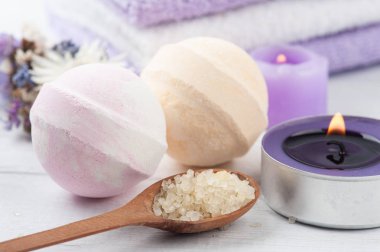 Aroma tuzu ve banyo bombaları, mor sünger taşı ve lavanta kaplama. Havlular, yanan mor mumlar. Yakın çekim.