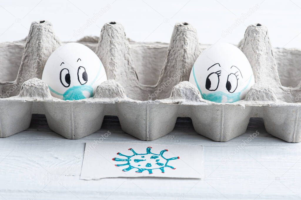 Two eggs in medical masks distanced one from other looking scared. Concept for virus protection and Easter cancelation