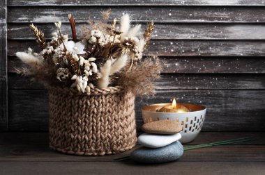 Şık ahşap arka planda Aroma altın mumu. Arka planda kurumuş çiçekler ve çakıl taşları