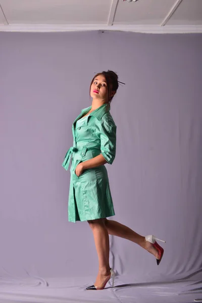 Model posing in light green raincoat standing in studio — Stock Photo, Image