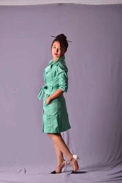 Model posing in light green raincoat standing in studio — Stock Photo, Image