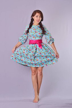 Siyah uzun elbise stüdyoda oturan kanatlı melek şeytan modelinde. Siyah arka plan,