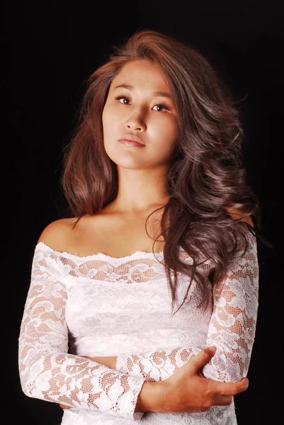 Portrait of a young model with long brown hair, bare shoulders, dark skin clean in guipure dress — Stock Photo, Image