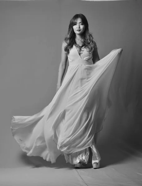 Młoda Azjatka model stwarzające w elegancka długa suknia łopocze na wietrze — Zdjęcie stockowe