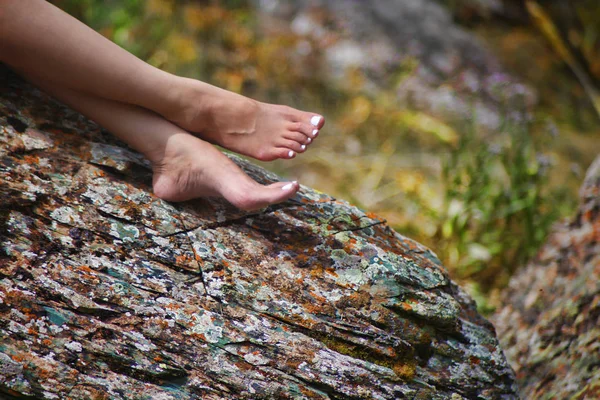 Женские ноги на скале. Лето Лицензионные Стоковые Изображения