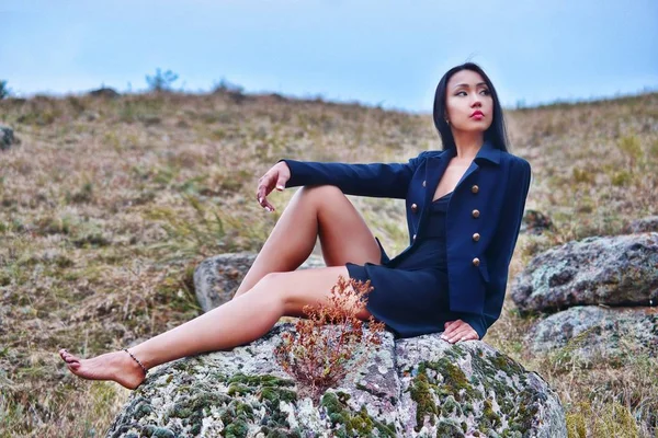 Model posing on nature sitting on stones — Stock Photo, Image