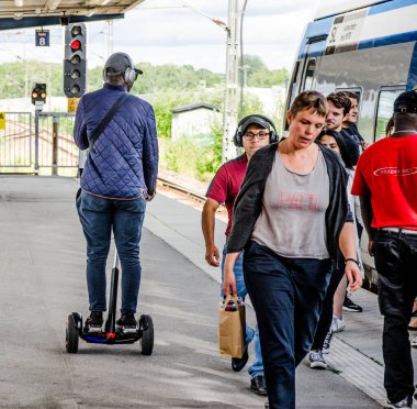 Stockholm, İsveç 'teki tren istasyonunda segway tipi taşımacılık yapan adam.