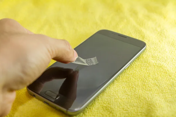 Membersihkan layar telepon seluler dengan pita perekat yang jelas — Stok Foto